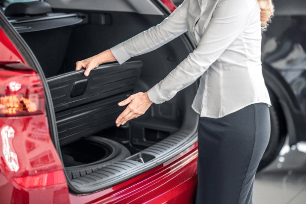 mulher mostrando estepe de seu carro