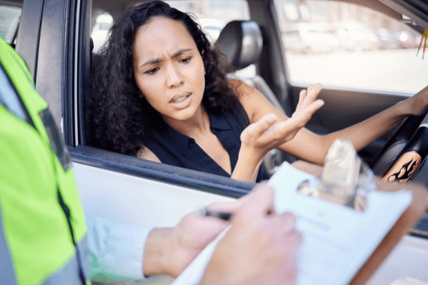 mulher recebendo multa de trânsito por excesso de velocidade